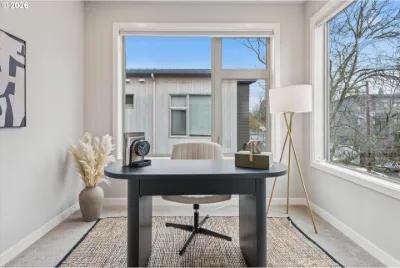 Townhome room staged as a home office with a dark desk and white chair