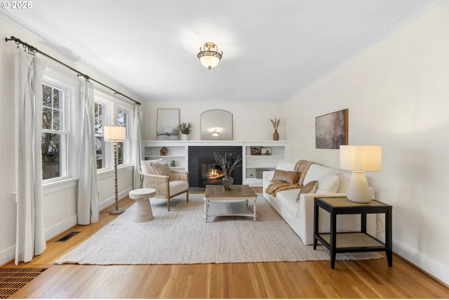 Classic Portland cottage living room staged with cream sofas, a fireplace and white built-in shelves